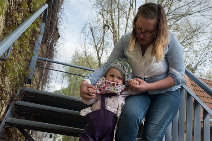 Frau hilft Kleinkind auf der Treppe